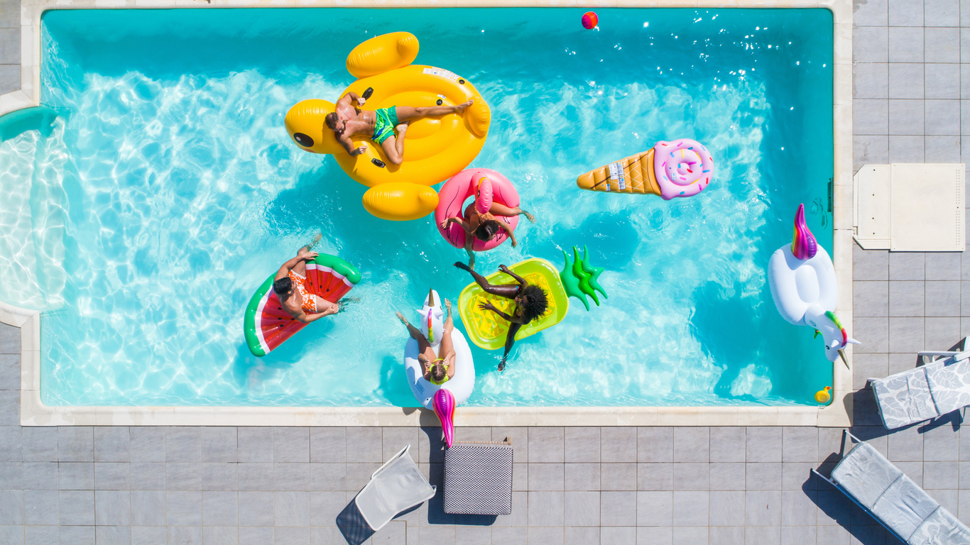 The image shows a group enjoying time in a pool to represent the reasons to add a custom pool to your home.